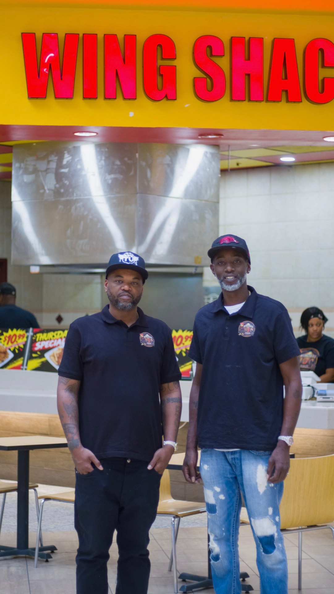 The owners of Wing Shack 3 standing together in front of the counter